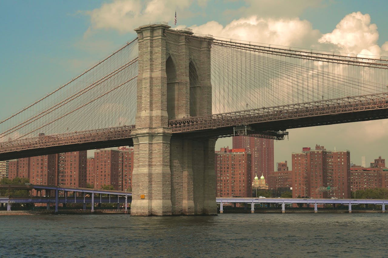 A classic view of the iconic Brooklyn Bridge with New York City's urban landscape in the background.